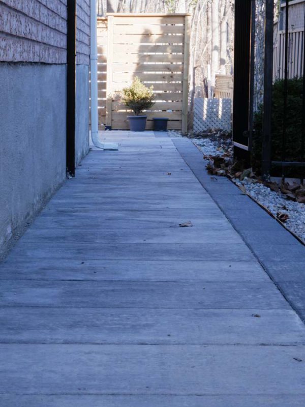 Patio made with Cassara slabs in grey mix color, with precast steps leading to a top landing. Slabs are 50mm thick and laid in a running bond pattern