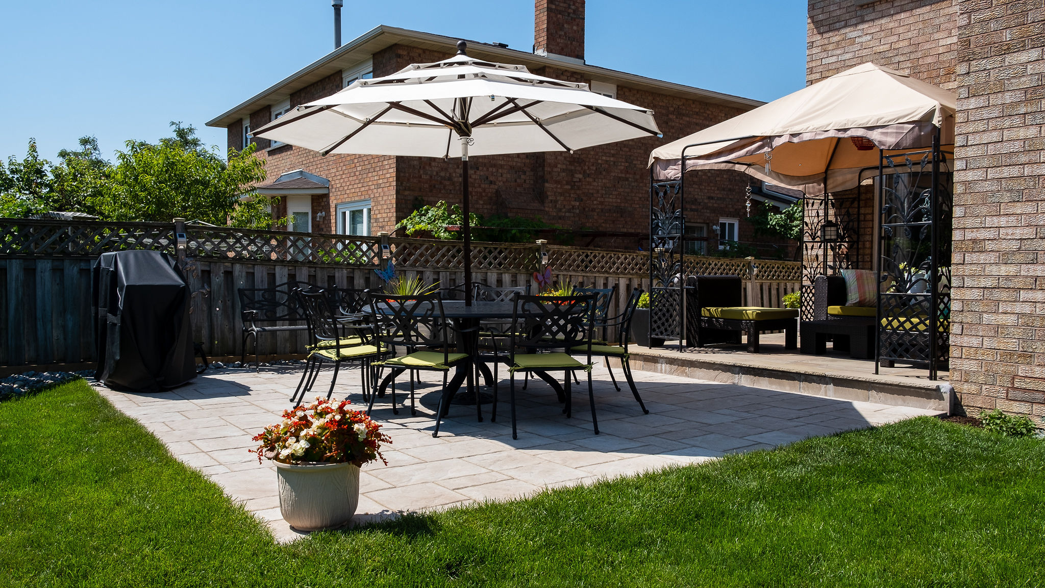 Backyard patio design featuring Beacon Hill Pavers in 60mm thickness. In addition, there is a porch with flagstone in Lavender color.